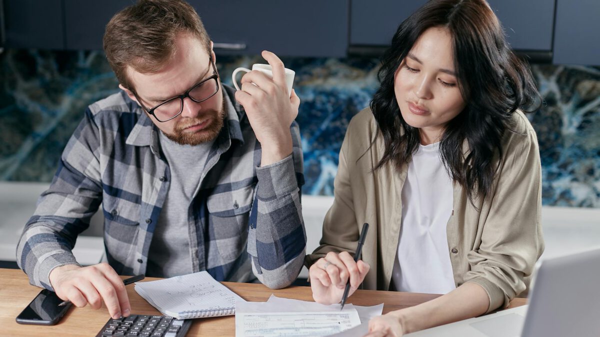 First-time home buyers in Edmonton reviewing real estate paperwork and avoiding costly mistakes