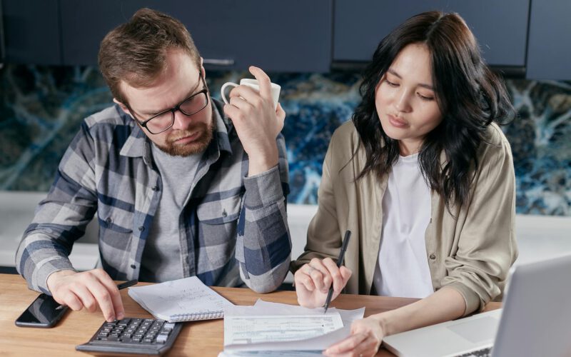 First-time home buyers in Edmonton reviewing real estate paperwork and avoiding costly mistakes
