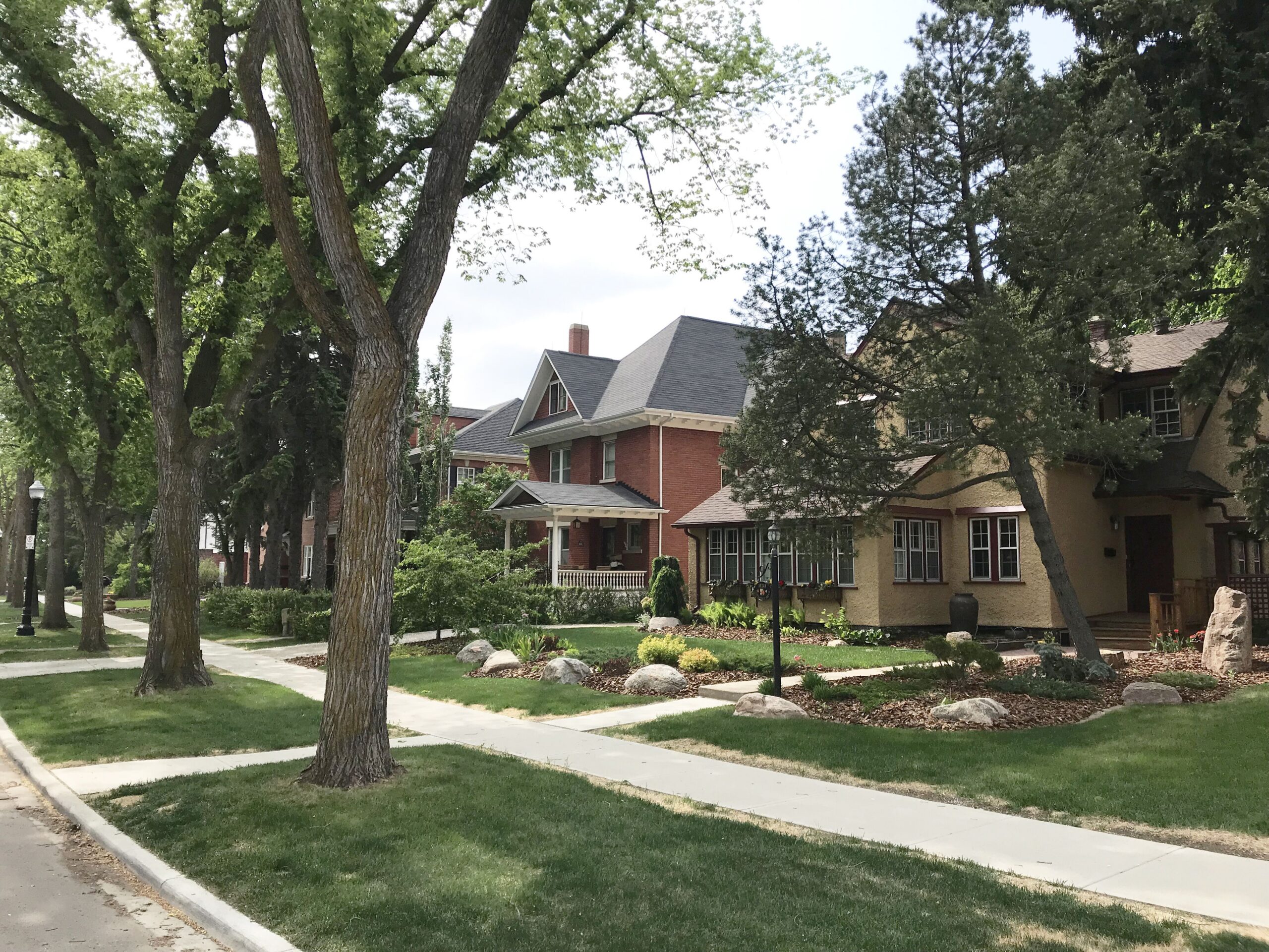 Two-storey home with Craftsman details and cedar shake accents, illustrative of the heritage architecture styles common in mature inner-city Edmonton neighbourhoods.