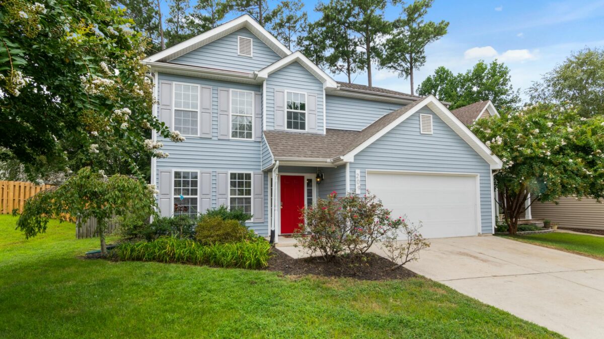 A two-story family home with a bright red front door and attached garage, representing residential property in Edmonton.