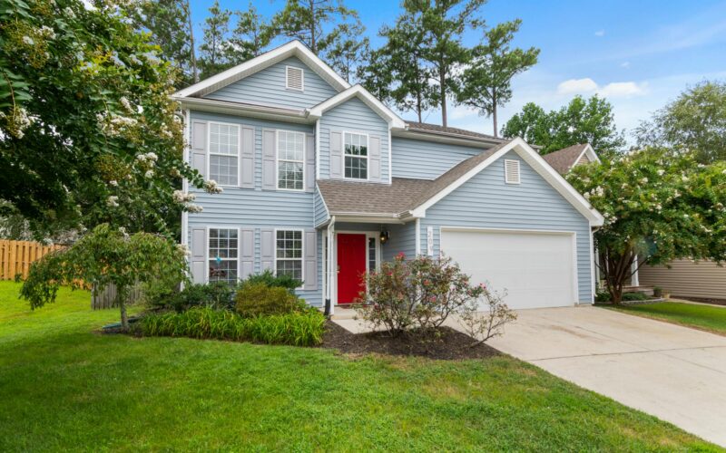 A two-story family home with a bright red front door and attached garage, representing residential property in Edmonton.