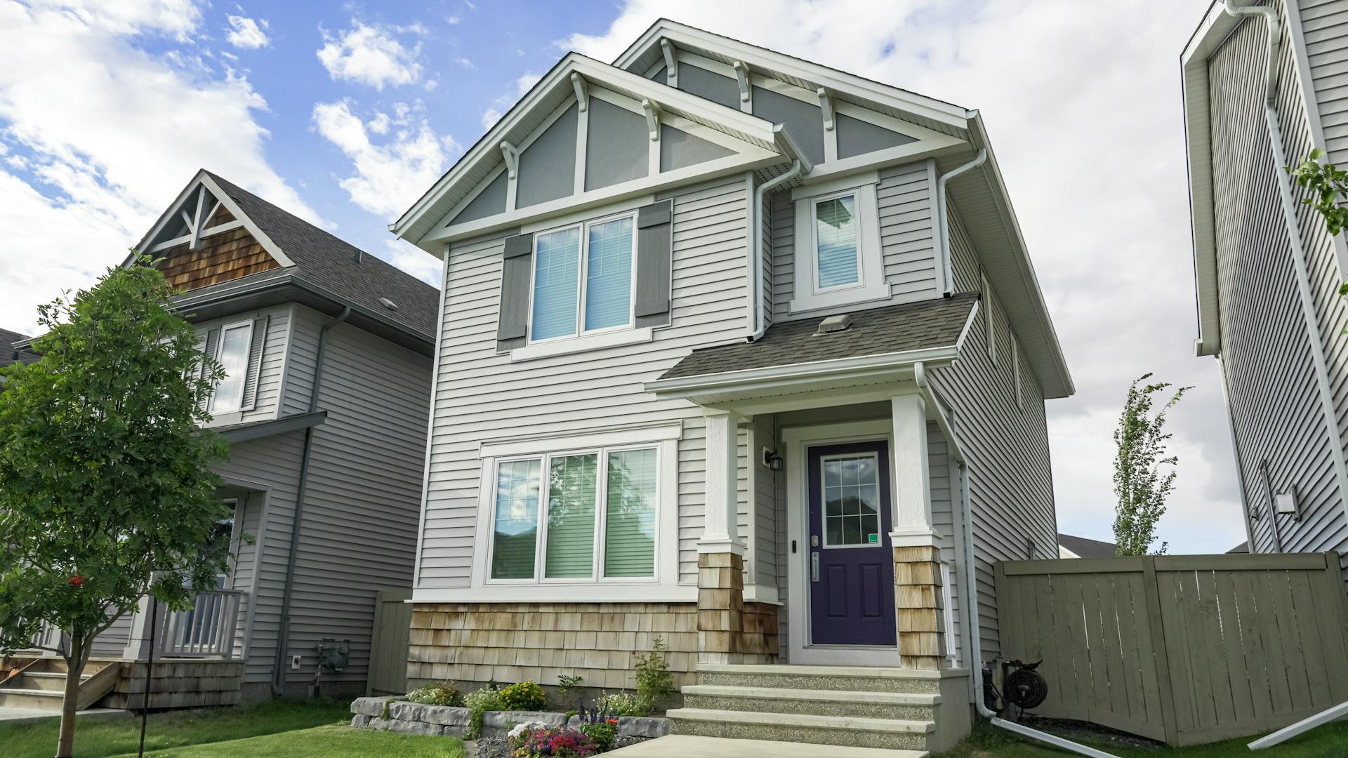 A grey two-storey home with craftsman details and cedar shake accents, typical of the newer detached homes for sale in Chappelle, Edmonton
