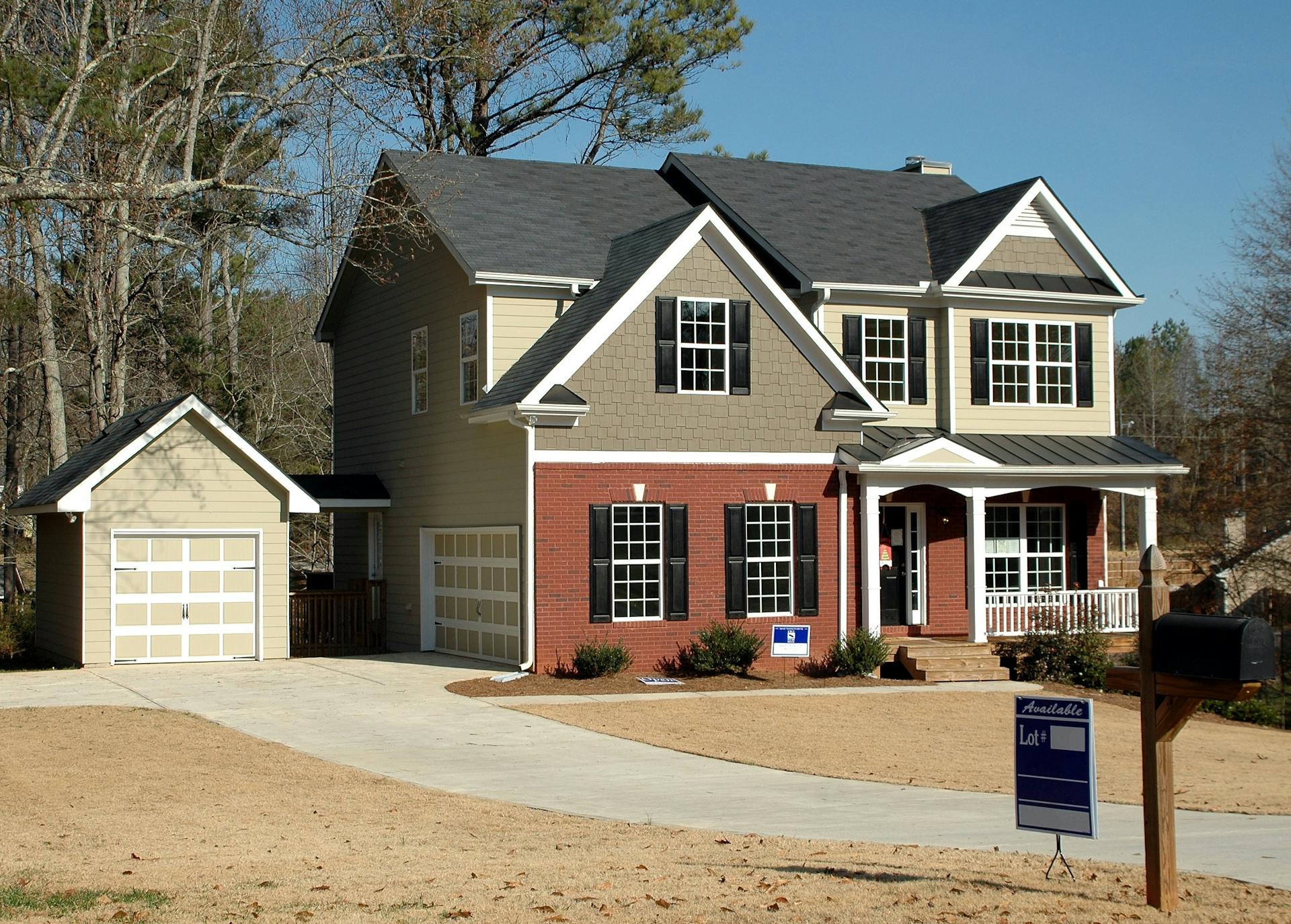 A newly built two-storey home with a brick and siding exterior and a detached garage, illustrative of newer housing of the kind found in The Orchards at Ellerslie, Edmonton